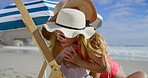 Chair, hug and mother with daughter on beach together for holiday, travel or vacation in summer. Love, relax or wellness with single parent woman and girl child embracing on sand by ocean or sea
