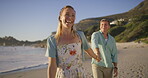 Couple, woman and walking by ocean, love and talking on vacation for romance on honeymoon. People, holding hands and playful on tropical island, support and drag husband by waves on weekend date