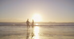 Blur, silhouette and sunset with couple on beach together for love, relationship or romance. Holiday, travel or vacation with man and woman holding hands on sand at sea of tropical island paradise