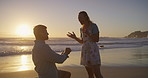 Surprise, sunset or couple at beach for proposal for romance, love or commitment offer. Engagement, holiday vacation or man on knee to ask shocked woman question on valentines day or anniversary date