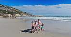 Back, family and walking with holding hands on beach for summer vacation, tropical journey and bonding together. Parents, children and ocean water with holiday fun, calm morning and travel adventure
