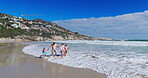 Family, water and holding hands with walking on beach for summer vacation, tropical journey and bonding together. Parents, children and ocean waves with holiday fun, calm morning and travel adventure