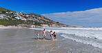 Family, walking and holding hands with water on beach for summer vacation, tropical journey and bonding together. Parents, children and ocean waves with holiday fun, calm morning and travel adventure