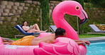 Pink flamingo, couple and relax with swimming pool, vacation and summer holiday. Outdoor, water and man with woman, float toy and calm with peace, getaway trip and travel with happiness and journey