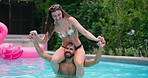 Summer, pool party and couple with laughing, splash and bonding at hotel or resort. Swimming, shoulder carry and man with woman, water and balance for holiday event, vacation celebration or fun