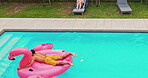 Aerial, couple and relax in swimming pool outdoor for summer vacation, luxury resort and honeymoon trip. Drone, man and jumping with inflatable flamingo, water and holiday destination of relationship