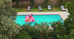Drone, couple and relax in swimming pool outdoor for summer vacation, luxury resort and honeymoon trip. Aerial, people and rest with inflatable flamingo, water and holiday destination of relationship