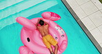 Back, man and floating in swimming pool outdoor for summer vacation, luxury resort and hospitality trip. Aerial, male person and relax for inflatable flamingo, water and holiday destination at lodge 