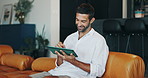 Happy man, tablet and relax on sofa for social media, streaming service or entertainment in living room at home. Male person, smile and rest on lounge couch with technology for online video at house