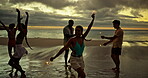 Happy, woman and dancing with sparkler on beach for ocean party, travel reunion and bonding together. Friends, people and fireworks with rhythm movement, holiday celebration and sunset of sea getaway