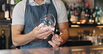 Bartender, hands and cleaning glass in pub for hygiene, dust removal and workflow routine. Barista, hospitality industry or person wiping glassware at counter for disinfection, bacteria or sanitation
