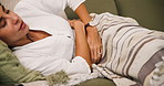 Stress, sofa and woman with stomach pain in home in morning with ache for periods and ibs in lounge. Menstrual, sick and belly discomfort from endometriosis with crisis, pms or digestion problems