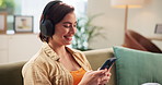 Home, smile and woman with mobile for headphones, podcast and connection for streaming. House, female person and relax with smartphone for application, online website and listening to music on couch