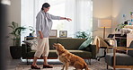 Woman, home and training dog with treats for mental stimulation, behavior reward and domestic companion. Foster pet, owner and golden retriever in lounge with bonding, animal care or learning command