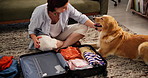 Woman, packing suitcase and pet at house for travel, trip preparation and pet friendly destination. Female person, playing and puppy with luggage, getting ready and bonding together of animal getaway