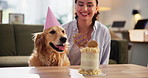 Birthday, cake or love with dog and woman in living room of apartment together for celebration. Party, smile or treat with pet owner and labrador in apartment for bonding, friendship or milestone