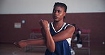 Basketball, sports and woman stretching on court for game, tournament or competition with workout. Fitness, challenge and African female athlete with arm warm up exercise for match with training.