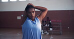 Arms, basketball and stretching with black woman on sports court for training preparation. Exercise, fitness and warm up with African athlete in gymnasium for start of competition, game or match