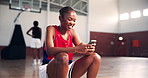 Laughing, basketball or woman with phone in university on social media for break or entertainment. Happy, smile or African girl athlete on mobile for workout, funny joke or fitness training on court