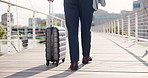 Legs, luggage and man in city, business and bridge with urban town, international travel and export. Closeup, corporate professional or employee with import company, suitcase and walking with commute