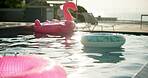 Pool, float and toys in water at sunset, shimmer and check out time at holiday resort. Accommodation, empty and recreational area at luxury hotel with inflatable animal, hospitality and travel spa