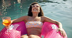 Happy woman, relax and drink with inflatable at pool party for summer vacation, holiday or weekend. Female person, lying and cocktail with smile for swim, vitamin D or relaxation at luxury resort