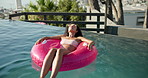Woman, relax or pool with inflatable for vacation, summer holiday or outdoor weekend at luxury resort. Calm, female person or relaxation with sunglasses on float for vitamin D, break or rest in water