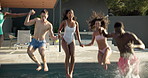 Bonding, having fun and splash with friends in swimming pool together for holiday or vacation. Jumping, party and water with group of people outdoor at hotel, lodge or resort for weekend getaway