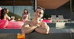 Face, party and happy man with confidence in swimming pool together for holiday or vacation. Relax, summer and person in water with alcohol, friends or people at hotel, lodge or resort for weekend