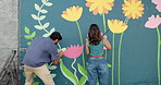 Wall art, friends and painting mural with brush for creativity, community project and student hobby. Woman, man and people for artist with diy decor, painter and flowers with expression outdoors