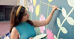 Wall art, woman and painting mural with brush for creativity, community project and student hobby. Girl, smile and people for artist with diy decor, painter and flowers with expression outdoors