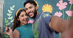 Couple, selfie and mural on wall outdoor with smile of people together for community art project. Creative, face or painting with man and woman in city for bonding, culture or social upliftment