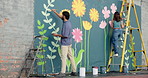 Wall art, team and painting mural with people for creativity, community project and student hobby. Woman, man and friends for artist people with diy decor, painter or flowers with expression outdoors