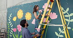 Wall art, team and painting mural with help for creativity, community project or student hobby. Woman, man and friends for artist people with diy decor, painter or flowers with expression outdoors