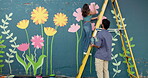 Couple, painting and help with wall art for mural design, creativity and decoration of community project. Man, woman and support as artist with hobby, flower aesthetic and bonding for diy inspiration