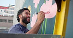 Painting, wall and mural with man in city for street artist, urban design or environment activist. Flowers, sustainability awareness and creative with painter outdoor for earth day, color and culture