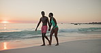 Holding hands, sunset or black couple at beach walking for vacation, anniversary or honeymoon holiday. Paradise, talking or romantic people bonding at sea together for travel, relationship or trip