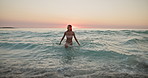 Water, beach and woman with waves, vacation and sunset with summer holiday, weekend break or travel. Ocean, traveller or happy person with journey, tropical island or trip with fun or walking in Bali
