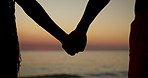 Silhouette, sunset or couple holding hands at beach for vacation, anniversary or honeymoon holiday. Paradise, closeup or romantic people bonding at sea together for travel, relationship or ocean trip