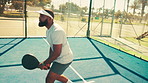 Sports, tennis court and black man with padel for playing, match and competition outdoors. Fitness, athlete and person with ball for training, exercise and workout for tournament, game or practice