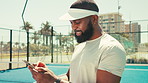 Sports, happy and black man with phone on tennis court for social media, online chat and internet. Athlete, fitness and person on smartphone typing after training, exercise and workout for game