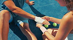 Paddle tennis, pain and bandage on hand for first aid, health or top view on court outdoor. Hurt, injury and man wrap wound for wellness, accident treatment and medical help after sports training