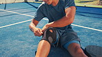 Sport athlete, injury and hands with knee brace on court for pain management, joint support or fitness accident. Padel tennis, person and kneecap protection for tournament practice or sprain recovery