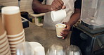Milk, hands and barista prepare coffee for drink, latte art and cappuccino in small business. Cafe, foam and man making beverage with steam dairy for heart shape, pouring cream and morning brew
