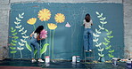 Back, people and friends for painting of wall for creative mural, community project and artistic freedom. Women, artist and brush for public art, flower design and local culture for therapeutic hobby