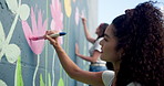 Wall art, girl and painting mural with brush for creativity, community project and student hobby. Women, friends and people for artist with diy decor, painter and flowers with expression outdoors