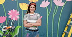 Face, happy and woman with brush for painting of wall mural, community project and artistic freedom. Portrait, person or arms crossed for public art, flower design and local culture of creative hobby
