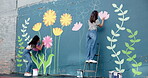 Wall art, women and painting mural with ladder for creative, community project and student hobby. Girl, friends and people for artist with diy decor, painter and flowers with expression outdoors