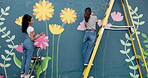 Wall art, people and painting mural with teamwork for creative, community project and student hobby. Friends, women and ladder for flowers artist, diy decor and painter with expression outdoors