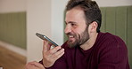 Happy man, conversation or phone call with speaker at cafe for voice note or vocal recording. Male person, freelancer or communication with smile on mobile smartphone for audio message at coffee shop